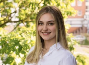 Jana – Teammitglied der Kanzlei, Porträt im Profil vor grünem Hintergrund